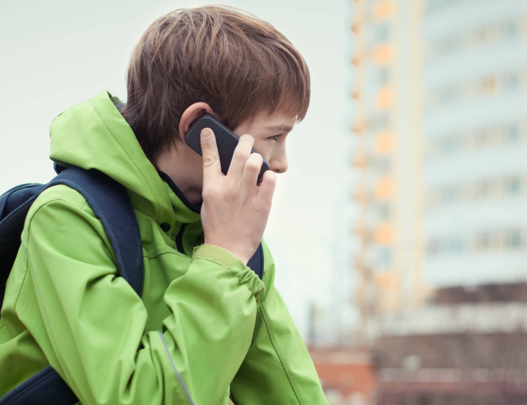 A boy holding a mobile phone to his ear