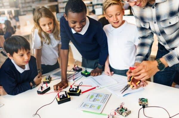 A group of school children and a teacher doing an experiment on a table